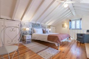 a bedroom with a bed and a table and a chair at Chão do Rio - Turismo de Aldeia - Serra da Estrela in Seia