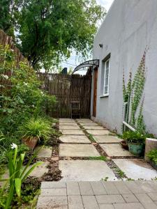 a walkway in front of a house with a fence at Wamelia Guesthouse in Bloemfontein