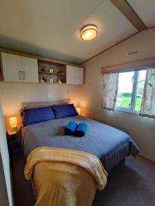 una camera da letto con un grande letto con cuscini blu di LuaMar Holidays- Tattershall Lakes - Lancaster Crescent a Tattershall