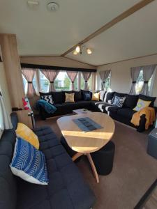 un soggiorno con divano e tavolo di LuaMar Holidays- Tattershall Lakes - Lancaster Crescent a Tattershall