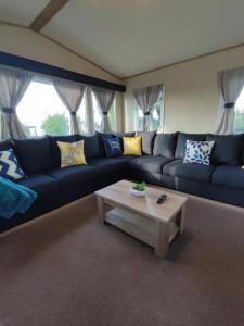 a living room with a blue couch and a coffee table at LuaMar Holidays- Tattershall Lakes - Lancaster Crescent in Tattershall