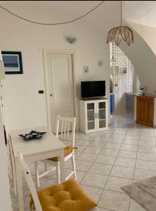 een keuken en een woonkamer met een tafel en stoelen bij CASA PALOMA in Sanremo