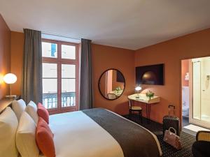 a hotel room with a bed and a window at Mercure Nantes Centre Passage Pommeraye in Nantes