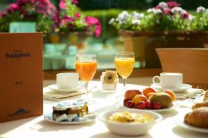 a table with two glasses of orange juice and food at Hotel Portonuovo in Vieste