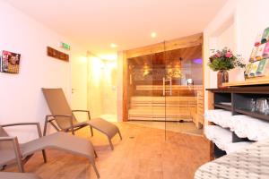 a living room with chairs and a glass shower at Landhaus Bromm in Riezlern