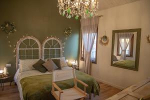 1 dormitorio con 1 cama con silla y lámpara de araña en La Casetta. Feel at home., en Castelfidardo