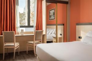una camera d'albergo con letto e scrivania con sedie di Sunotel Club Central a Barcellona