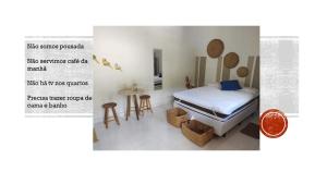 een slaapkamer met een bed en een tafel en stoelen bij Suítes Boissucanga in Boicucanga