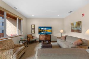 a living room with a couch and a tv at Trails Edge Condo Townhouse A in Leavenworth