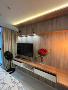 a bedroom with a television and a vase of flowers at Vista mare InterMares in Cabedelo