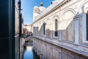 desde una ventana de un canal con un puente en Palazzo Miracoli Apartments en Venecia