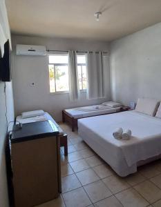 a hotel room with two beds and a television at San Conrado Hotel in Salinópolis