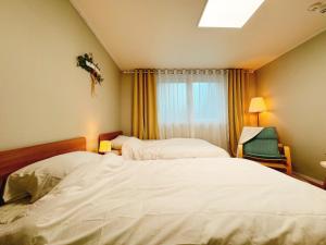 首爾的住宿－Digital media city station 2min DMC Stay Kpop Hongdae，配有窗户的酒店客房内的两张床