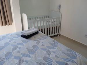 a bed with a crib in a bedroom at Apartamento completo A42 Flat Centro in Mogi das Cruzes