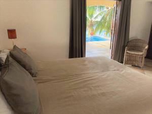 a bedroom with a bed with a view of a pool at Beach Villa Casa del Mar in Kralendijk +18 photos