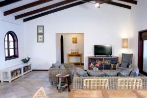 a living room with couches and a flat screen tv at Beach Villa Casa del Mar in Kralendijk