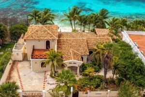 an aerial view of a house with palm trees and the ocean at Beach Villa Casa del Mar in Kralendijk