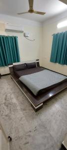 a large bed in a room with green curtains at MSD villa in Puducherry