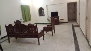 a living room with two chairs and a television at MSD villa in Puducherry