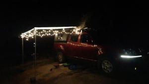 a red truck with christmas lights on the side of it at Gowri Nature Farm Stay in Hampi