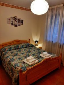 a bedroom with a bed with towels on it at CIVICO 43/B in Chiesa in Valmalenco