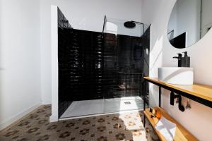 y baño con ducha, lavabo y espejo. en Casa Sabai, en Las Palmas de Gran Canaria