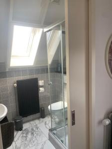 a bathroom with a glass shower and a toilet at Bed en Bike Texel in Den Burg +34 photos