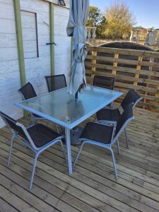 einen Tisch und Stühle auf einer Terrasse mit einem Sonnenschirm in der Unterkunft Appartement avec terrain in Pézenas