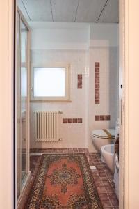 a bathroom with a toilet and a window and a rug at Loft del Faro in Fano