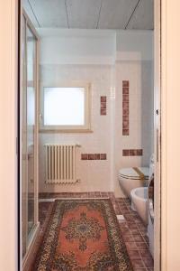 a bathroom with a toilet and a window and a rug at Loft del Faro in Fano +20 photos