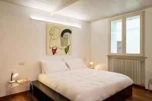 a bedroom with a large white bed and a window at Loft del Faro in Fano