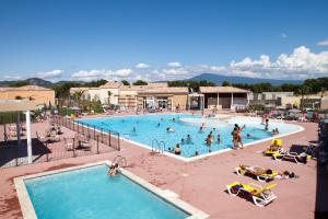 een groep mensen in een zwembad in een resort bij Vacanceole - Residence les Demeures du Ventoux in Aubignan