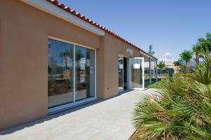 a building with large glass windows and plants at Vacanceole - Residence les Demeures du Ventoux in Aubignan