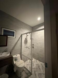 ein Bad mit einer Dusche, einem WC und einem Waschbecken in der Unterkunft Suntalee House in Nai Yang Beach