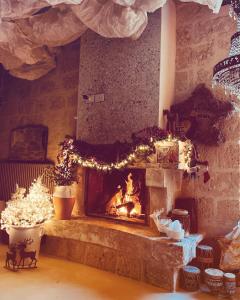 un soggiorno con camino e luci di Natale di Hydria guest house art gallery ad Acquaviva delle Fonti