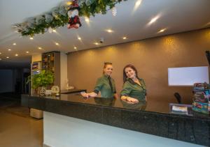 two women standing at a counter in a restaurant at Infinity Hotel in Medellín