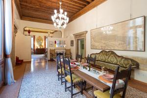 a dining room with a table and chairs and a chandelier at Fortuny 3967 Luxury suites wine in Venice