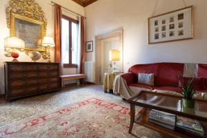 a living room with a red couch and a table at Fortuny 3967 Luxury suites wine in Venice +53 photos
