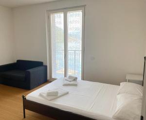 sypialnia z łóżkiem, krzesłem i oknem w obiekcie The Duplex - Big Apartment with Terraces w mieście Argegno