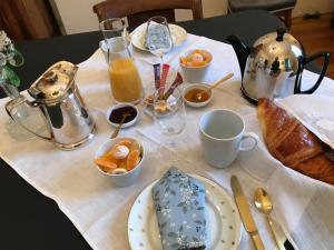 una mesa con desayuno de pan y zumo de naranja en La Gardinière, en La Barre-de-Monts