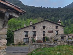 a large stone building with a mountain in the background at 4LLARS in Beget