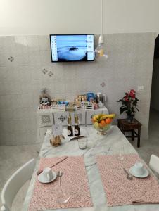 een keuken met een tafel en een tv aan de muur bij A CASA IDA in Bagnoregio