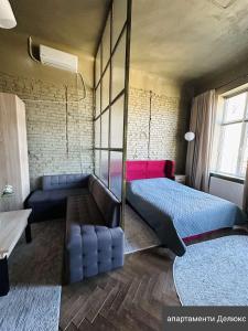 a bedroom with two beds and a couch at Apart hotel на Франка in Chernivtsi