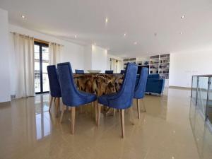 a dining room with blue chairs and a table at Charming Caminha Villa - 4 Bedrooms - Villa Caminha View - Private Pool and Astounding Sea Views - Viana do Castelo in Caminha