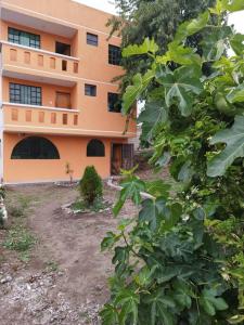 un bâtiment orange avec une cour devant dans l'établissement 4 Suite Balcón estelar Ambato, à Ambato