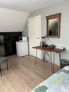 um quarto com uma mesa, um micro-ondas e um frigorífico em Hazegewoud em Arendonk