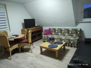 sala de estar con sofá y mesa en Kaya Ferienwohnungen, en Plettenberg