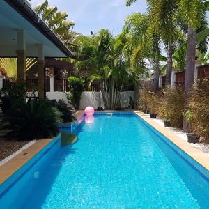 una piscina en un patio con palmeras en Project 17 en Hua Hin