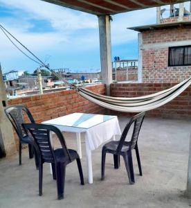 a hammock and a table and chairs on a roof at Departamento de Pablito Junto al Mar in Caleta Cruz