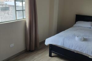 a bedroom with a bed and a large window at 2 Cuarto independiente en Ambato in Ambato